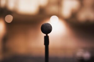 Musical Steps of Courage blog post by Ken Walker Writer. Pictures a microphone in an large room.