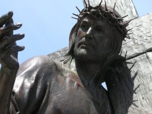 Pictured a statue of Christ carrying a cross, with a crown of thrown on his head.