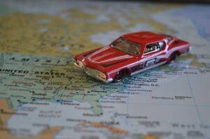 The GPS Travel Nightmare blog post by Ken Walker Writer. Pictuures a model car sitting on a map of the USA, Canada and Mexico.