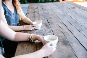 Taking Time for Others blog post by Ken Walker Writer. Pictured: Two people sit at a table sharing coffee.