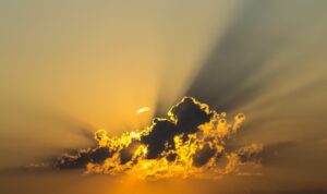 The Value of Testimonies blog post by Ken Walker Writer. Pictured: The sun rising behind a cloud.