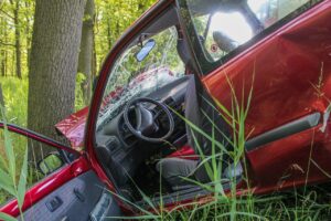 The Impact of Forgiveness blog post by Ken Walker Writer. Pictured: A mid-sized sedan crashed off the road and into a tree.