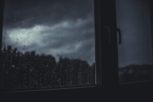 Inconvenience Is Not Suffering: Hurricane Helene blog post by Ken Walker Writer. Pictured: A darkened window with rain on it.