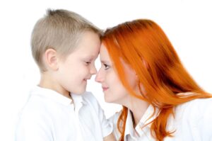 Honoring Our Parents Brings a Promise blog post by Ken Walker Writer. Pictured a young son, forehead to forehead with his mother.