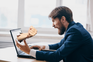 Pictured: An angry man yelling at his laptop, and aa fist striking out from the screen.