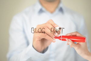 All Writers Need an Editor blog post by Ken Walker Writer. Pictured: A Man writing Blog Post on a board while an editor works in a red pen on the other side.