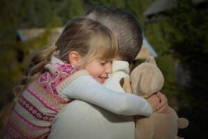 Pictured: A little girl  hugs her dad.