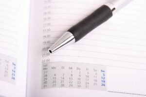 Pictured: A paper schedule and pen.