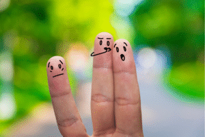 Pictured: 3 fingers being held up. From left to right; One has a face drawn up on it that is sad, one has a face drawn up like it is sharing an insult, one has a face like it is shocked at the insult.