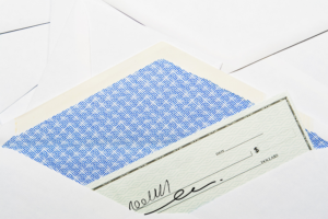 Miracle Stories Worth Reading blog post by Ken Walker Writer. Pictured: A check peeking out from an envelope.